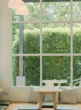 Large glass window with multiple panes overlooking a green space